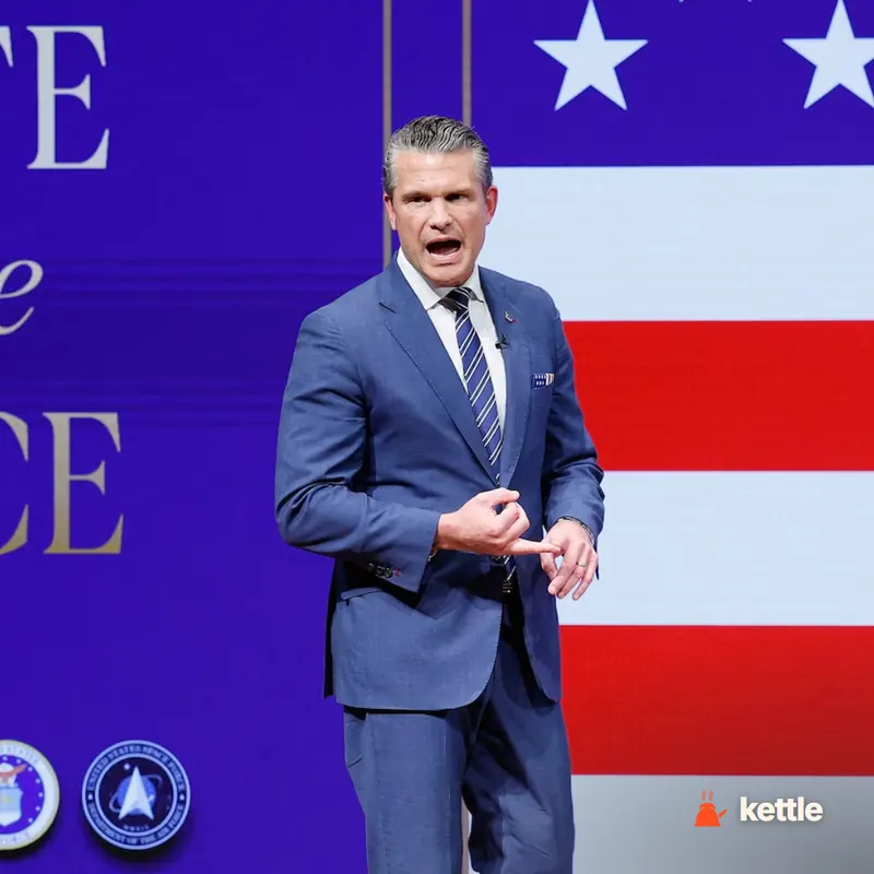 Pete Hegseth speaking animatedly at a podium with a U.S. flag backdrop and military seals