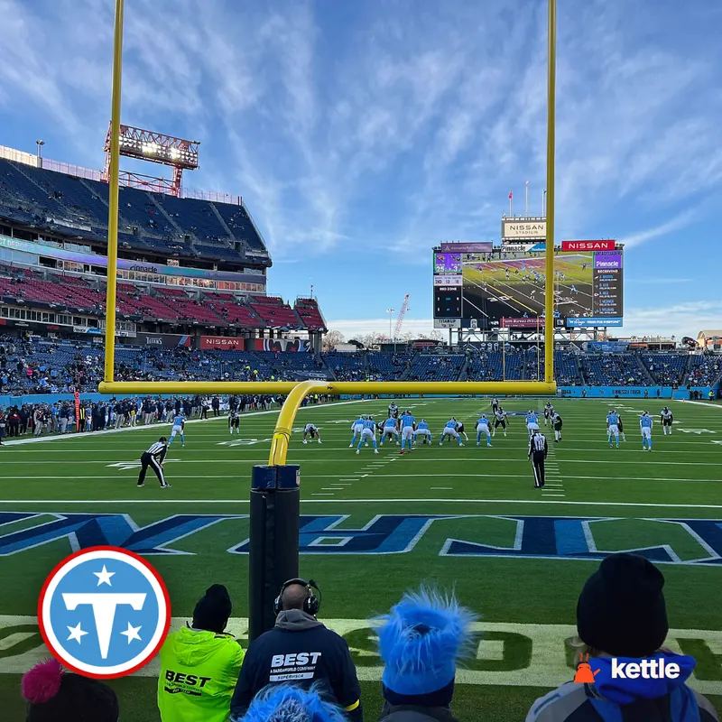 Nissan Stadium football field in play, with the Tennessee Titans logo overlaid on the bottom-left corner