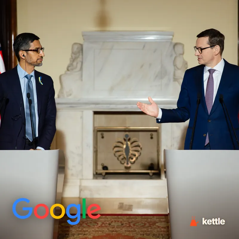 Sundar Pichai standing at a podium with another man at a press event, with a Google logo overlay at bottom left