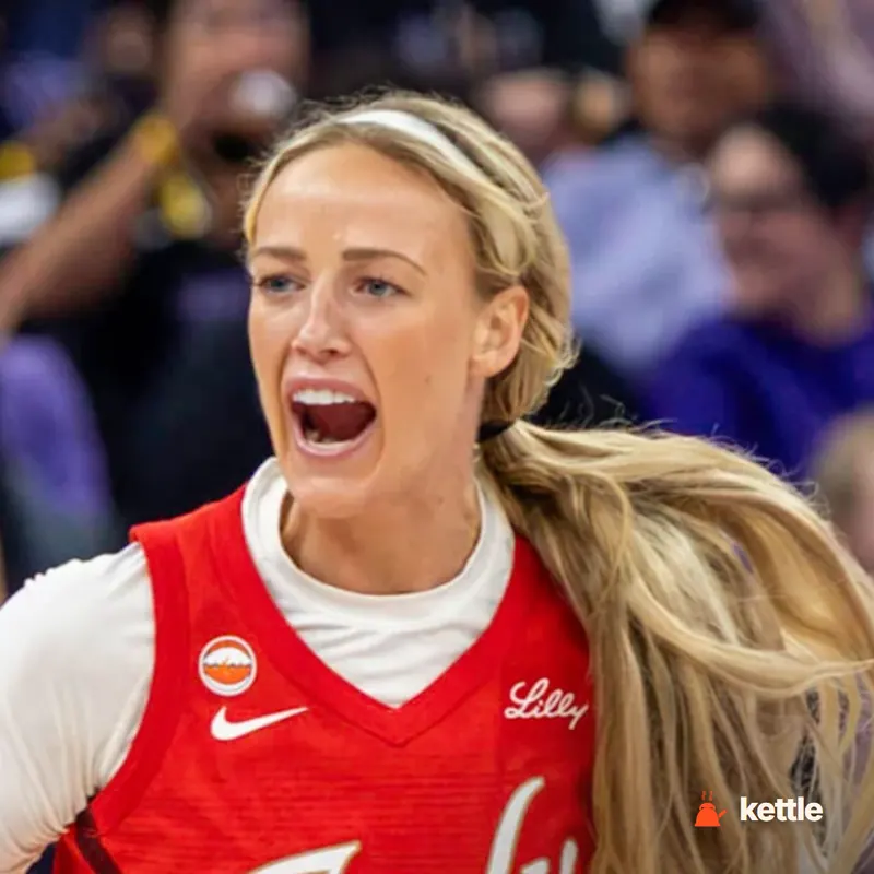 A blonde female basketball player in a red Indiana Fever jersey, shouting on court — likely Sophie Cunningham